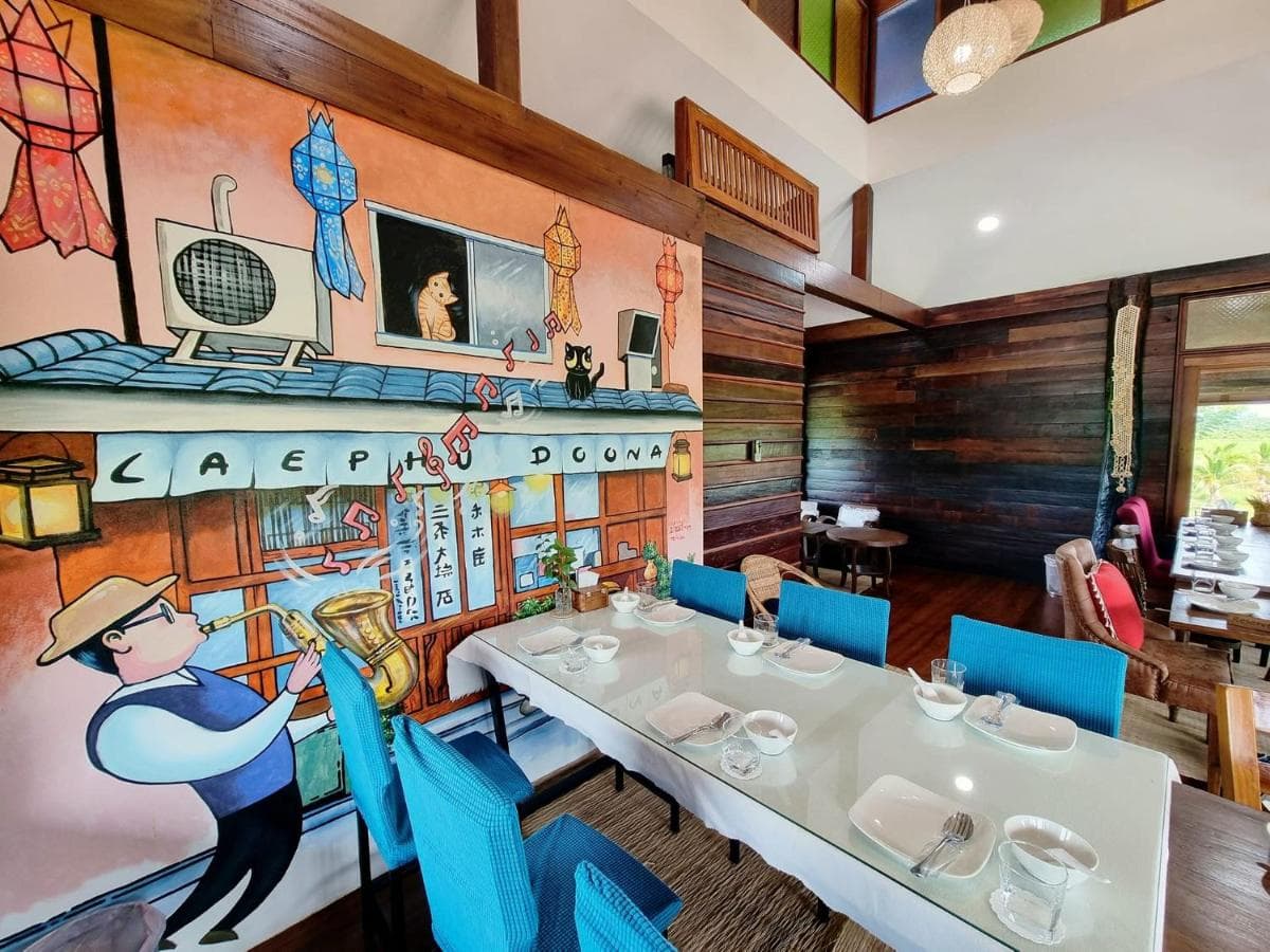 The warm dining room at Doona Resort with blue chairs and a hand-painted mural